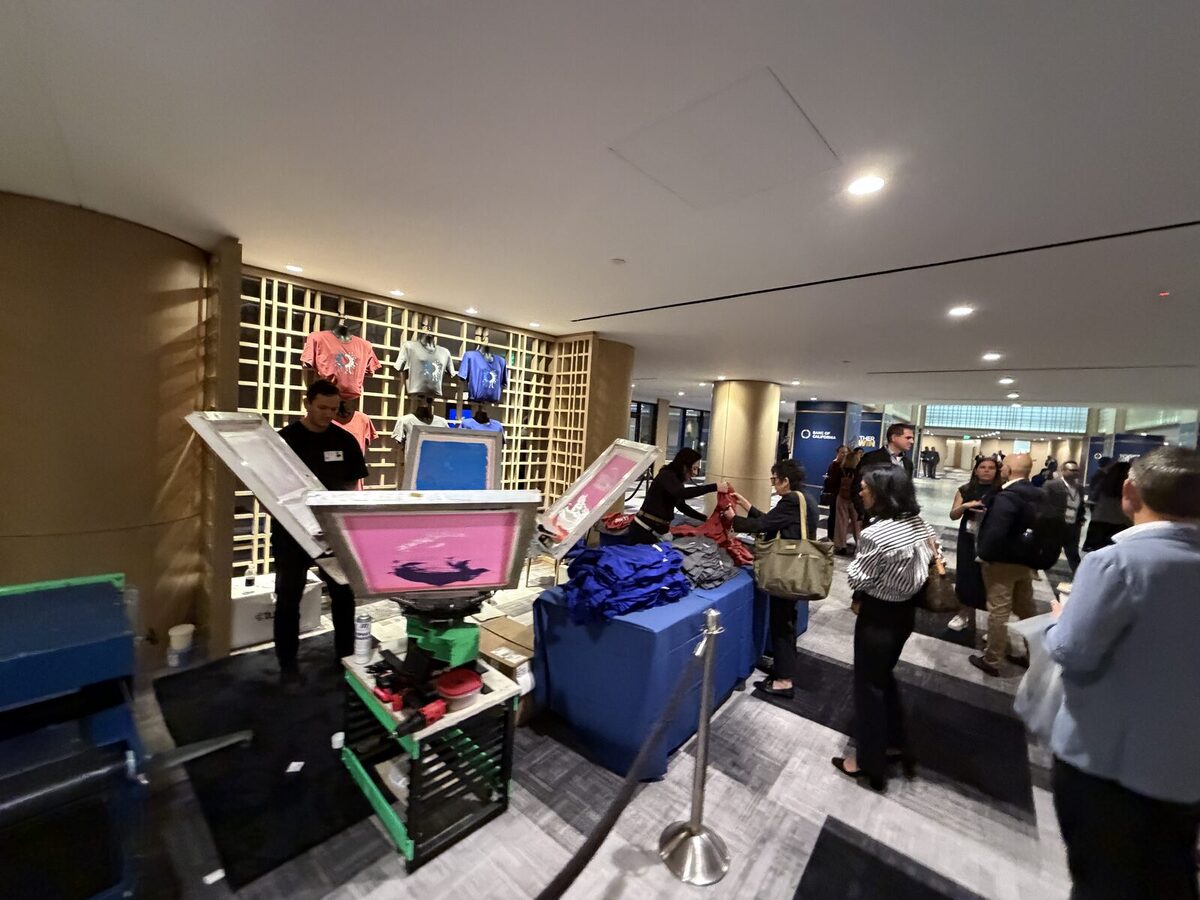 Crowd watching shirts get pressed at an event